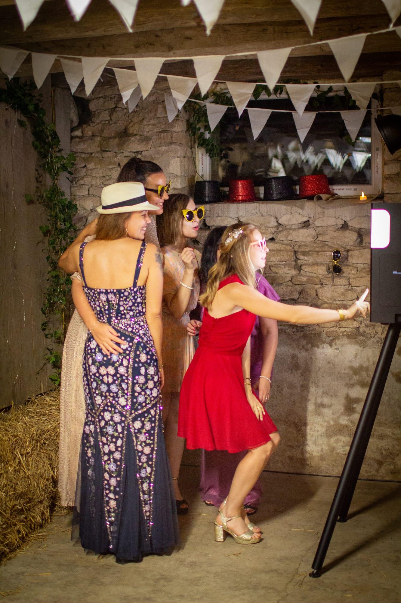 Invitées riant devant le photobooth sous les fanions